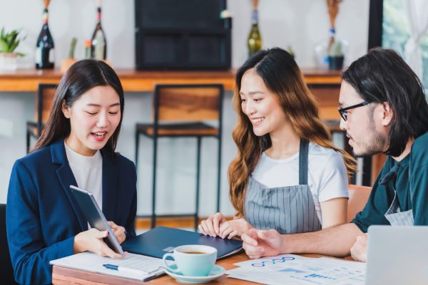 asian business women talking about business plan with coffee shop owner barista cafe