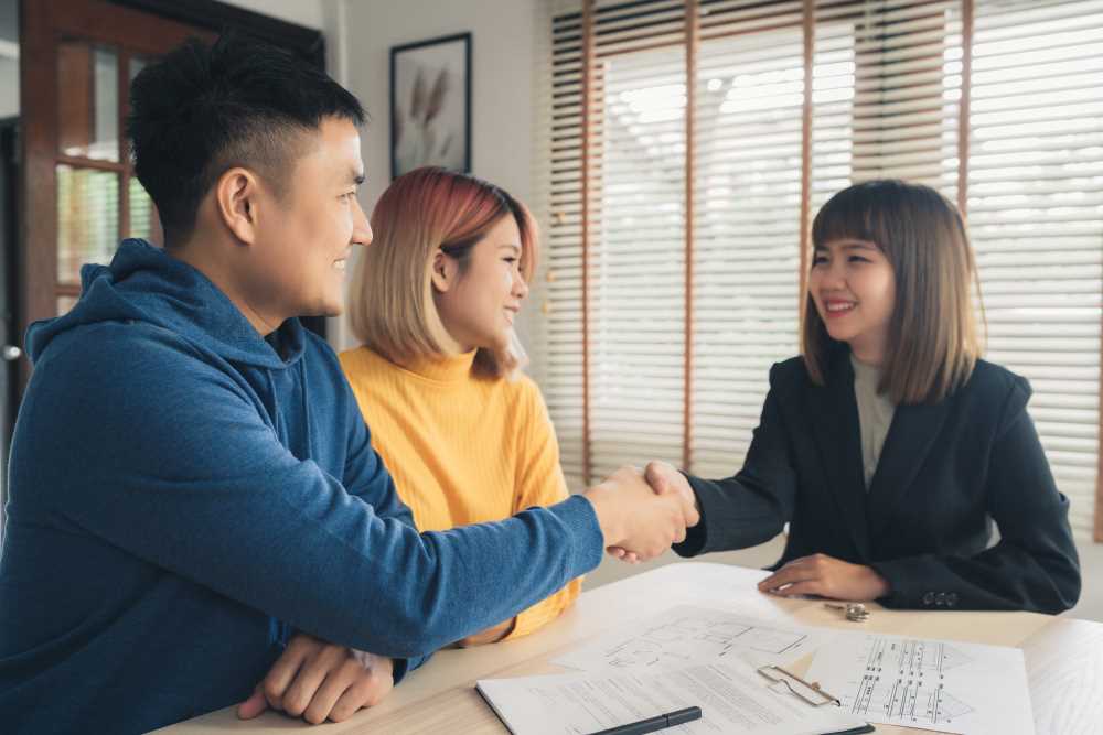 happy young asian couple realtor agent